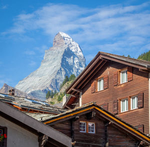 Houses by snowcapped mountains against sky