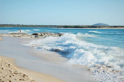 Scenic view of beach against clear blue sky