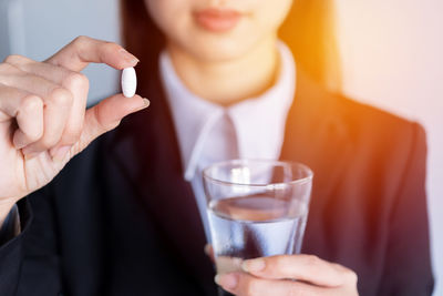 Midsection of woman drinking glass