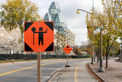 Traffic control person ahead road sign due to construction work in downtown of ottawa, canada