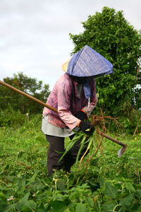 Farmer working at farm against sky