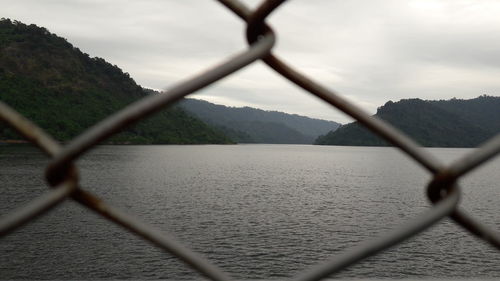 Close-up of chainlink fence against sky