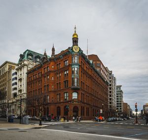 Road by buildings against sky in city