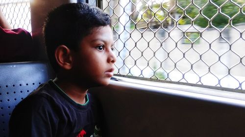 Portrait of boy looking through window