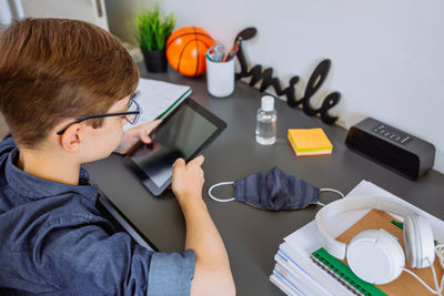 High angle view of boy studying at home