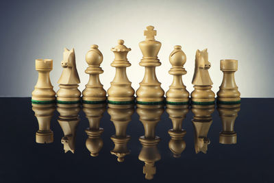 Close-up of chess pieces on table against white background