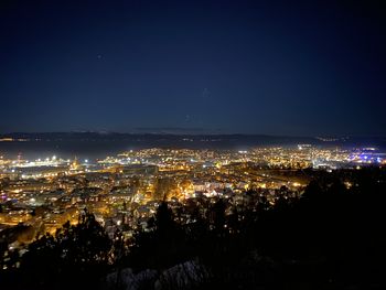 High angle view of illuminated buildings against sky at night