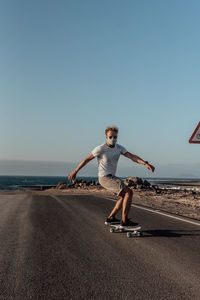 Full length of boy on beach against clear sky