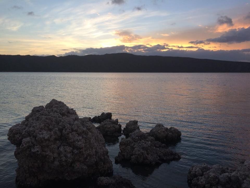 ROCKS IN SEA AGAINST SKY DURING SUNSET