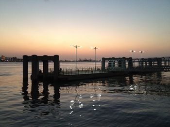 Pier on sea against sky during sunset