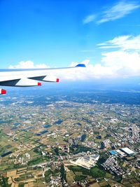 Airplane flying over townscape against sky