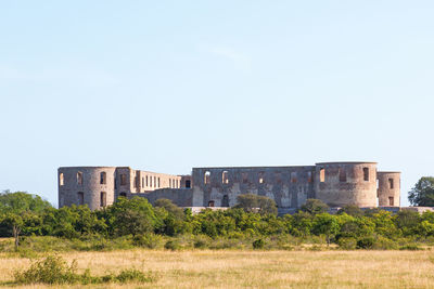 Old building in field against clear sky
