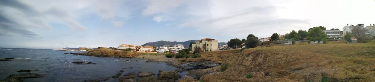 Panoramic view of sea and buildings against sky