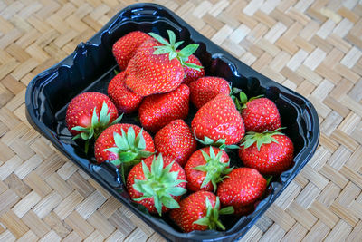 High angle view of strawberries in basket on table