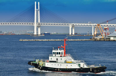 Suspension bridge over sea against sky