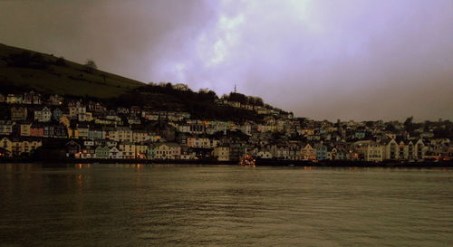 View of cityscape by sea against sky