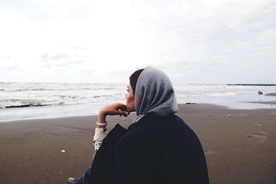 Rear view of woman standing on beach