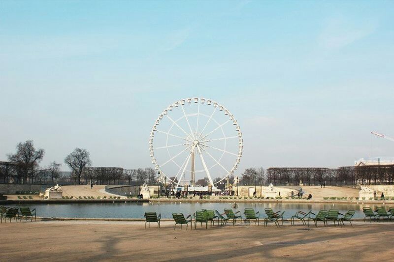 ferris wheel, amusement park, amusement park ride, arts culture and entertainment, beach, circle, sky, built structure, architecture, blue, clear sky, sea, water, incidental people, fun, vacations, tourism, enjoyment, large, tree