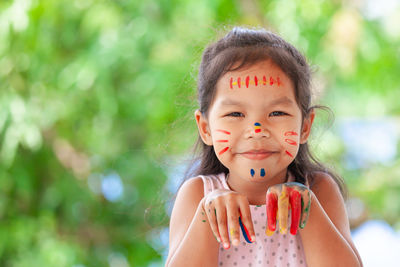 Close-up portrait of smiling girl with body paints gesturing