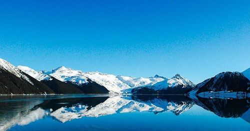 Scenic view of snowcapped mountains against blue sky