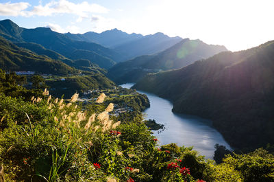 Scenic view of river and mountains against sky
