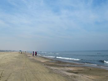 People on beach against sky
