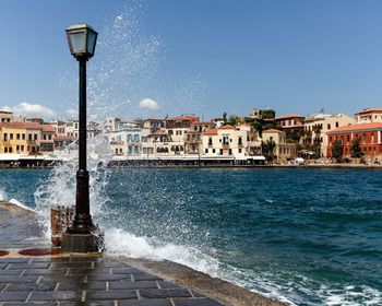 View of buildings at waterfront against blue sky