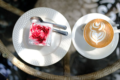 Hot cappuccino mocha latte coffee and strawberry cream cheesecake in plastic cup.