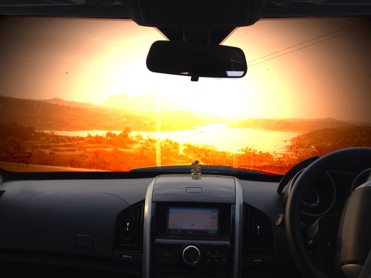 transportation, mode of transport, sunset, land vehicle, car, sun, vehicle interior, orange color, travel, car interior, side-view mirror, silhouette, windshield, part of, on the move, sky, sunlight, transparent, glass - material, journey