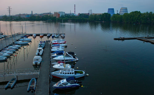 Boats moored at harbor during sunset