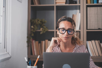 Smiling businesswoman using laptop at office