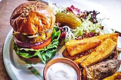 Close-up of burger with salad and dip served on plate