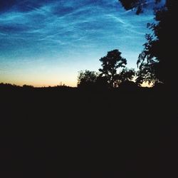 Silhouette of trees on landscape against the sky