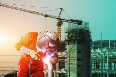 Man working at construction site against sky