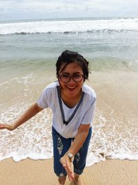 Cheerful woman running on shore at beach