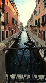 Canal amidst buildings in city against sky