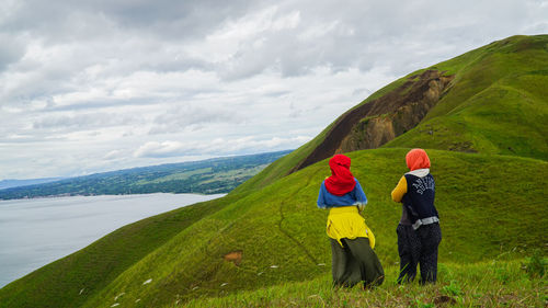 Rear view of two people walking on mountain road