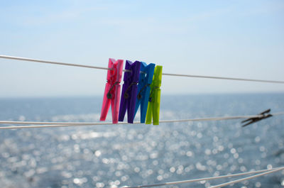 Close-up of clothes hanging on rope against sea