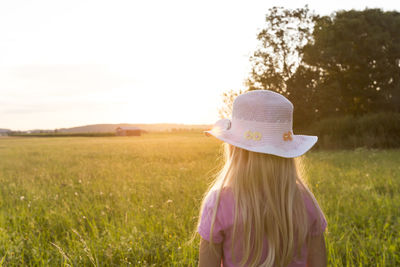 Rear view of woman wearing hat on field