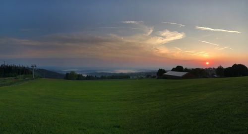 Scenic view of field against sky during sunset