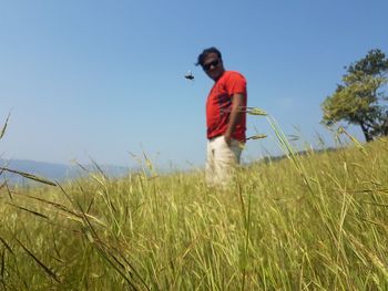 Man standing on field against sky