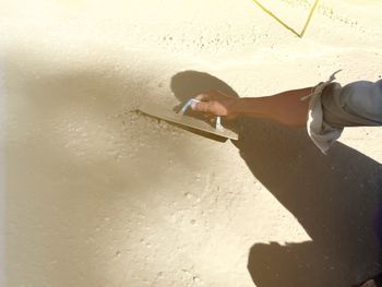 High angle view of man hand on sand