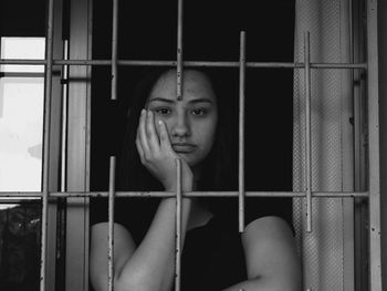 Portrait of woman against window
