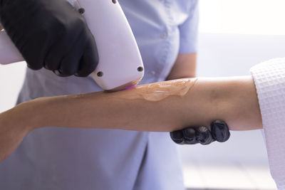 Midsection of doctor holding dental equipment