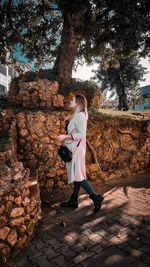 Rear view of woman standing by tree