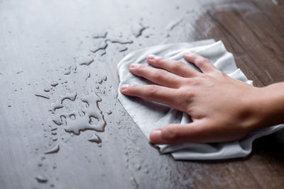 Close-up of hand touching book on table