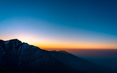 Scenic view of mountains against clear sky during sunset
