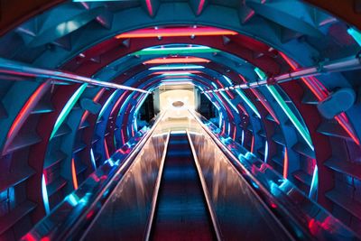 Moving walkway with colorful lights in tunnel