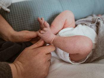 Midsection of baby hands on bed