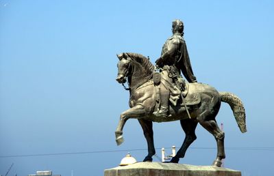 Low angle view of statue against clear blue sky